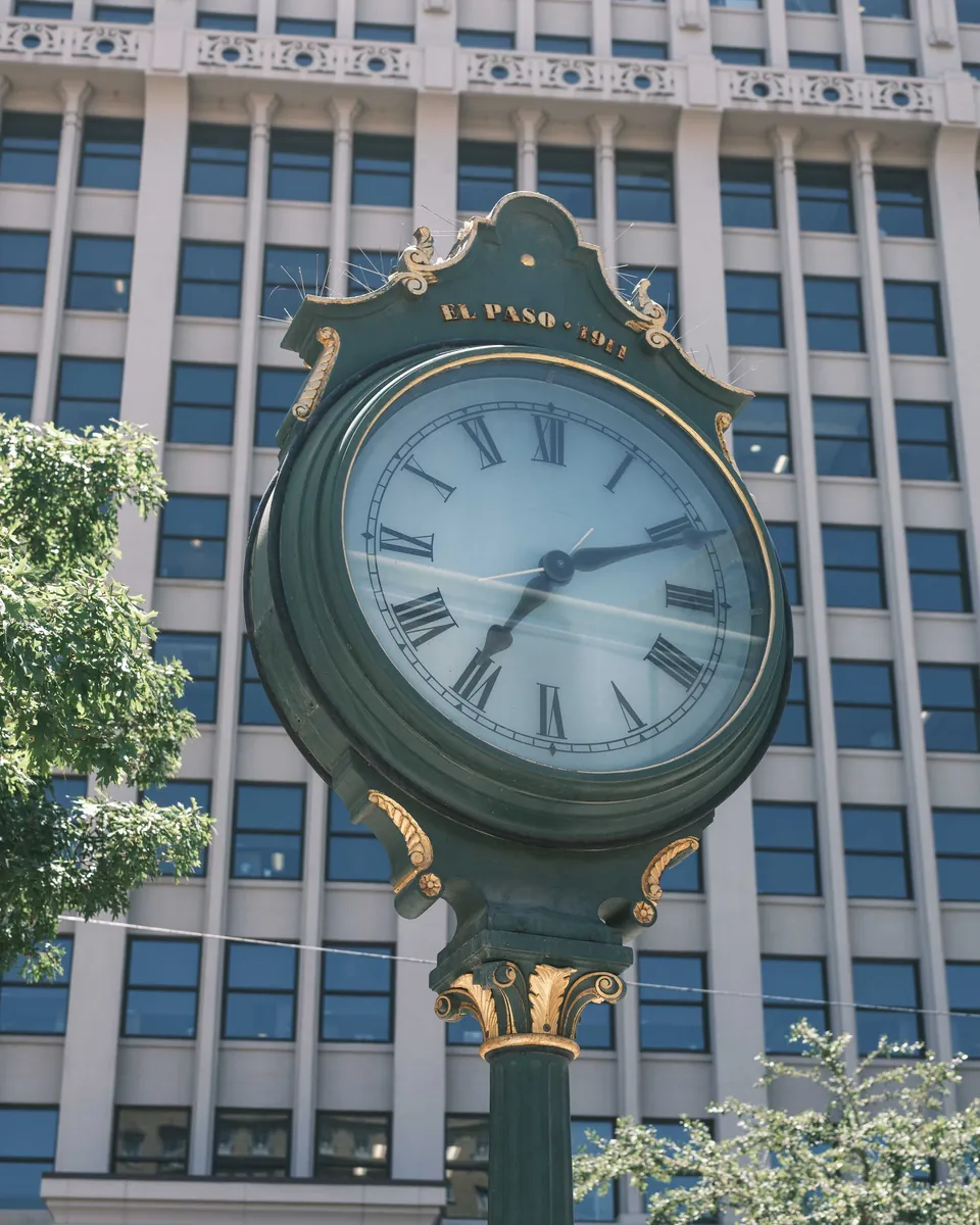 Historic street clock marked El Paso in front of an office tower in downtown El Paso, TX