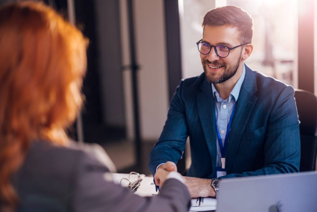 Man and woman shaking hands in office