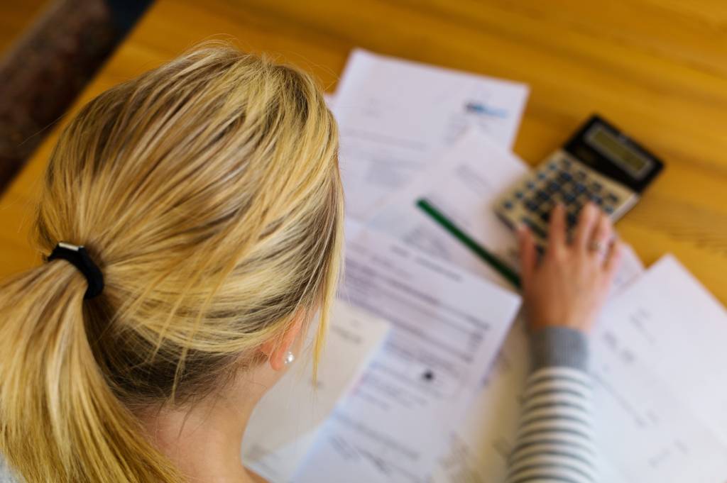 Close up of woman calculating tax bill to avoid substantial understatement penalty